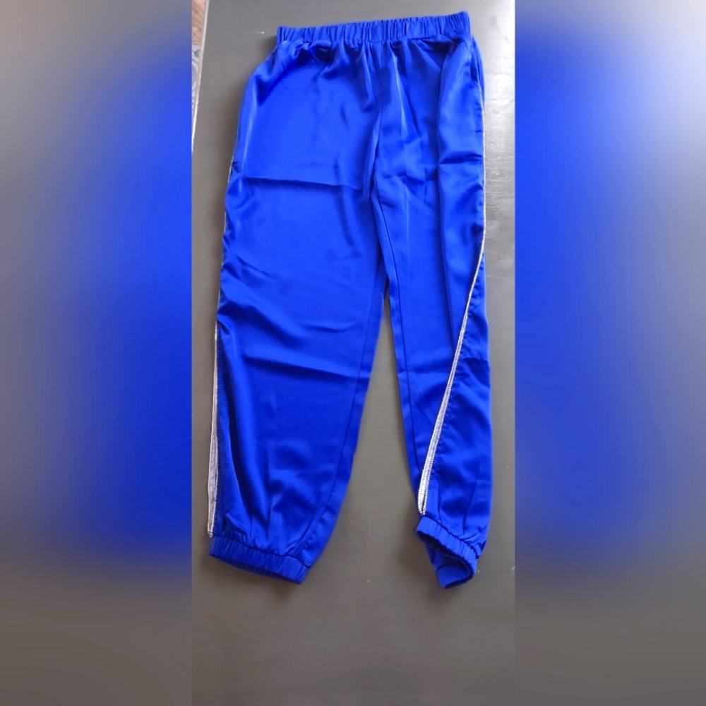 Women's shiny elastic high waist pants with rhinestone edging and cut outs.